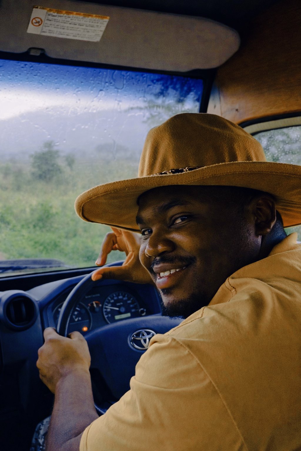 A guide smiling at the wheel of a safari vehicle