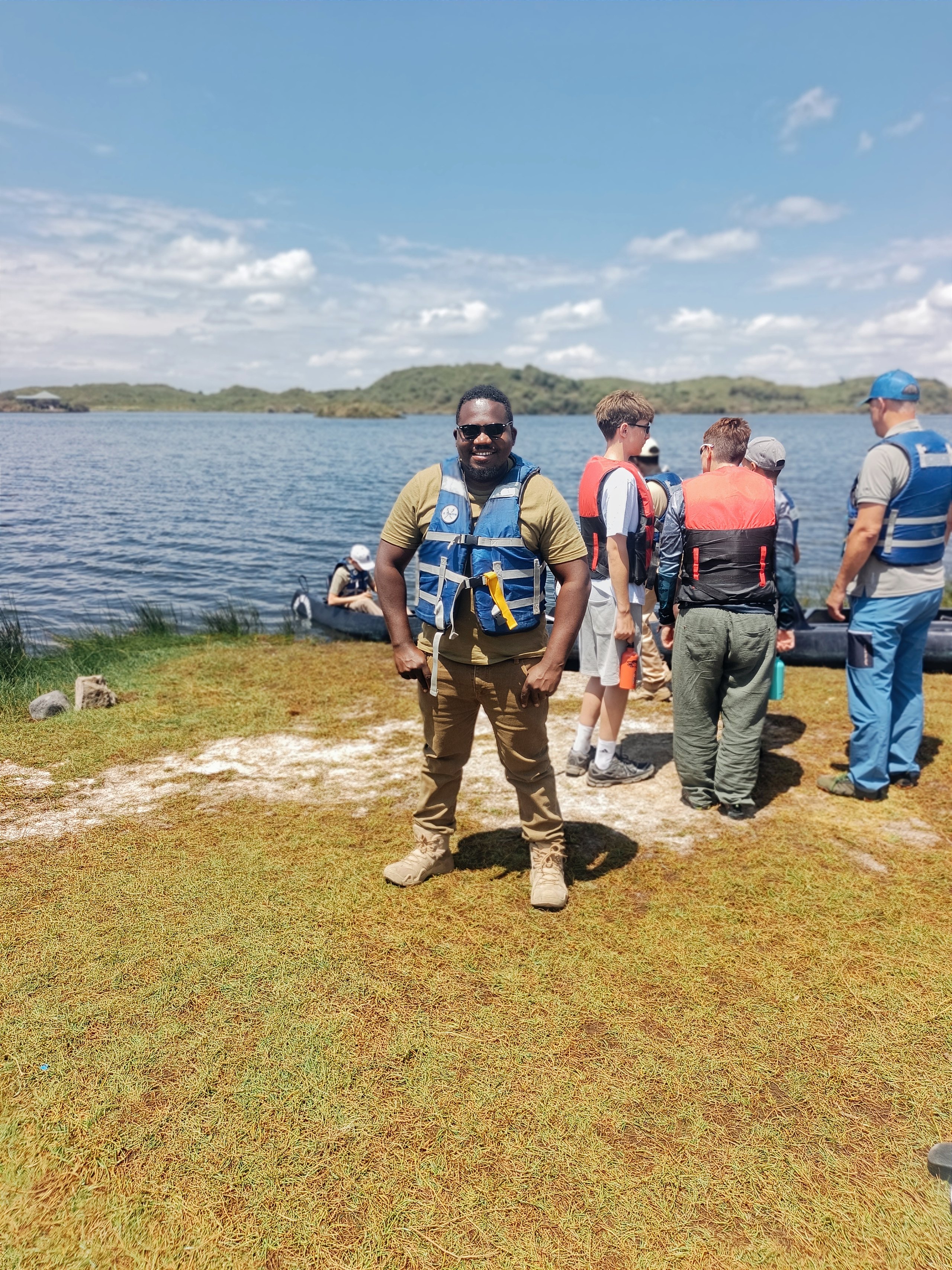 Guests and crew standing together on a lake shore